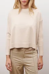 Buzo de punto color beige, con cuello redondo y manga larga.