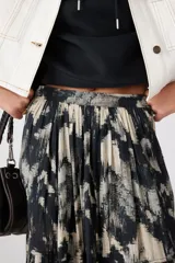 Pollera larga con estampado abstracto en tonos beige, negro y gris.