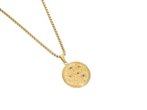 Collar dorado con dije redondo con diseño de árbol y circonitas multicolor.