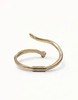 Pulsera abierta de diseño minimalista con acabado en plata, inspirada en la forma de un clavo con detalle de resorte central y grabado de la marca.