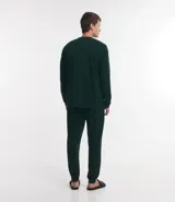 Pijama masculino de dos piezas confeccionado en tejido fleece texturizado. Incluye una remera de manga larga con cuello redondo y puños ajustados, y un pantalón tipo jogger con cintura elástica, cordón de ajuste y bolsillos laterales.