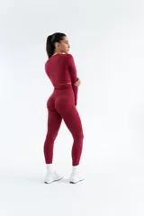 Remera deportiva de manga larga, confeccionada en tejido técnico elástico de color gris oscuro, con diseño ajustado al cuerpo y cuello redondo.