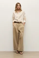 Camisa de manga larga color beige con diseño texturizado en tono sobre tono, cuello clásico y cierre frontal con botones.