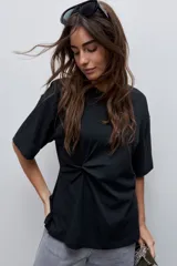 Remera de manga corta color blanco con cuello redondo y detalle de frunce lateral que aporta movimiento y una silueta entallada.