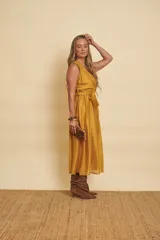 Vestido midi de organza color mostaza, de diseño cruzado adelante sin mangas, con escote en V y lazo ajustable en la cintura.