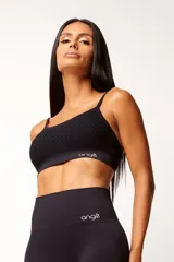 Top deportivo marrón con tecnología seamless, breteles finos y textura con microtramas respirables. Cuenta con forro interno.