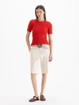 Top Charlotte de algodón y lino color negro, con calce al cuerpo, largo a la primera cadera, frunces en el exterior y escote semi alto con volado, al igual que los puños de las mangas cortas.