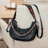 Cartera negra de cuero vacuno con textura croco, cierre superior, forro interior de tela con bolsillo para móvil, correa corta de cuero para usar al hombro, correa corta de cadena y correa larga ajustable y removible para usar como morral.