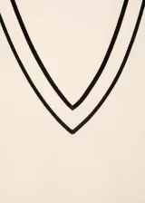 Jersey de punto fino en color crema con cuello de pico y detalles en contraste color marrón en el cuello y los puños. Presenta un diseño recto de manga larga.