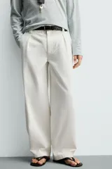 Pantalón barrel fit de hombre, confeccionado en denim de algodón color crudo. Presenta cintura con pliegues frontales, bolsillos laterales y cierre con cremallera y botón.
