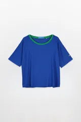 Remera oversized de tejido rib, color azul eléctrico, con mangas cortas y cuello redondo amplio con ribete verde.