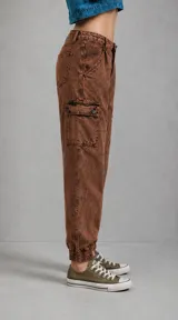 Pantalón tipo cargo de corte holgado en color marrón con efecto lavado oxidado. Presenta bolsillos laterales tipo cargo, cintura con trabillas y puños elásticos en los tobillos.