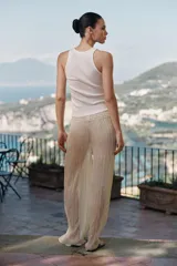 Top de cuello redondo y sin mangas, confeccionado en tejido de punto acanalado color crema. Presenta una aplicación asimétrica de tela tipo georgette en tono beige claro que cruza el frente de la prenda.