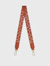 Correa bandolera Longchamp de cuero color tostado con diseño troquelado de hojas y mosquetones metálicos dorados en los extremos.