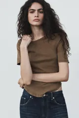 Camiseta de algodón color terracota con efecto lavado, cuello redondo y manga corta. Posee un bajo redondeado.