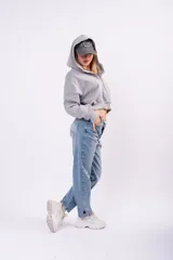 Jean mom fit de tiro alto en color azul claro con lavado vintage. Presenta un corte relajado y tajos laterales en el ruedo de los tobillos.