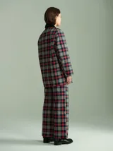 Pantalón de tiro alto con corte ancho y recto, confeccionado en tela de algodón con estampado de cuadros escoceses en tonos azul marino, verde y rojo. Presenta cierre frontal oculto con botones internos y pasacintos en la cintura.