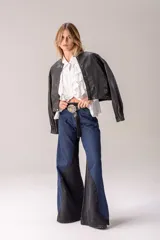 Jean wide leg de tiro alto en combinación de denim azul y negro, con diseño bicolor de paneles laterales en contraste y corte acampanado.
