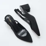 Zapatos de tacón medio y grueso color negro, con diseño destalonado, punta fina y tira ajustable con hebilla en el talón.