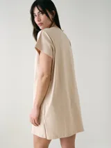 Camisón blanco de algodón, de corte holgado, manga corta y largo por encima de las rodillas. Presenta una pequeña estampa localizada en el pecho y aberturas en los laterales.