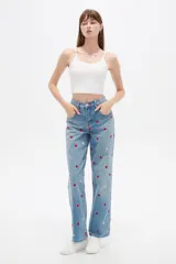 Pantalón jean de tiro alto y corte recto, color azul claro, con bordados de pequeños corazones rojos y rosados en toda la prenda.