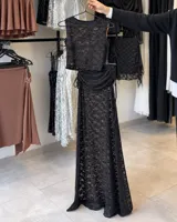 Pollera larga de encaje semitransparente, ajustada al cuerpo y con caída hasta el piso. Presenta frunce regulable con lazo lateral.