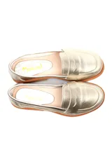 Mocasín plateado de cuero con detalle de vincha y suela plana color madera.