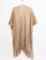 Ruana dorada de tejido calado con flecos.