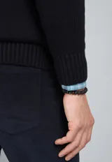 Sweater de punto trenzado color azul marino, con cuello redondo y mangas largas.