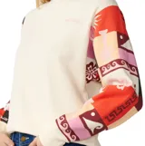 Buzo Rip Curl de color blanco con mangas largas estampadas con diseños coloridos y geométricos, cuello redondo y calce relajado.