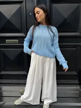 Sweater color crema tejido con diseño en ochos y cuello redondo.