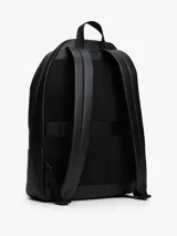 Mochila urbana Tommy Hilfiger de diseño minimalista en color negro. Presenta un compartimento principal amplio con cierre, un bolsillo frontal con cierre y detalle de franja tricolor distintiva de la marca. Incluye asa superior, correas ajustables acolchadas y logo metálico grabado en la parte superior.