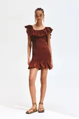 Vestido corto marrón de corte entallado, con diseño fruncido tipo nido de abeja en todo el cuerpo, escote cuadrado con hombros descubiertos y volados anchos en el escote y el ruedo.
