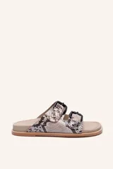 Sandalias planas con estampado de serpiente en tonos beige, gris y negro. Cuentan con dos tiras anchas ajustables con hebillas negras y suela de cuero.