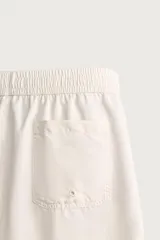 Short de baño largo en color beige, confeccionado en tejido técnico con tacto aterciopelado. Cuenta con cintura elástica ajustable con cordón, bolsillos laterales y detalle de bolsillo trasero, además de forro interior.