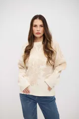 Buzo de tejido de punto con diseño floral en tonos crema y beige, de corte holgado, cuello redondo y mangas largas con puños acanalados.