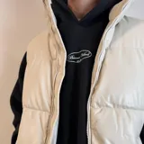 Chaleco puffer de cuero sintético en color negro, con diseño acolchado de paneles horizontales, cierre frontal completo y cuello alto.