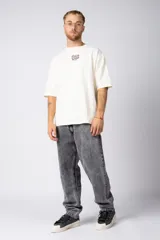 Jean de corte mom oversize, color negro lavado, con diseño de cinco bolsillos y cierre frontal con botón y cremallera.