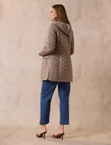 Campera capitoneada de corte largo con diseño acolchado en forma de rombos. Cuenta con cierre frontal completo, capucha desmontable, bolsillos delanteros con solapa y cierre, y forro interno a tono.