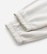 Pantalón jogger de algodón con felpa, color beige, con cintura elástica, cordón ajustable, bolsillos laterales y puños elásticos en los tobillos.