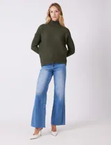 Buzo de tejido acanalado color blanco, con cuello alto y diseño de patrón en V en el frente. Presenta un corte holgado con mangas integradas sin costura de sisa.