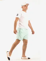 Short de baño amarillo con cintura elástica y logo pequeño en la pierna.