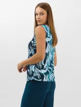 Conjunto de tres piezas compuesto por una musculosa de escote redondo, un saco largo abierto de mangas 3/4 y un pantalón palazzo de pierna ancha. La musculosa y el saco presentan un estampado abstracto de pinceladas en tonos azules con hilos metalizados, mientras que el pantalón es de color azul petróleo liso.