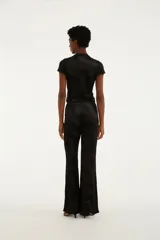 Pantalón negro de corte oxford y fluido, confeccionado en tejido de tul devoré con un delicado diseño estampado de flores en tono sobre tono.