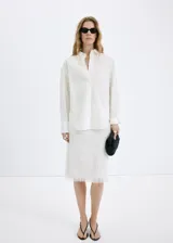 Camisa oversize blanca de mezcla de algodón y lyocell, con cuello camisero, manga larga, puños abotonados y detalle de perlas aplicadas en toda la prenda.