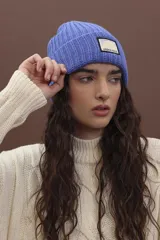 Gorro de punto fucsia con etiqueta de marca en el frente.
