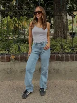 Jean tiro alto de algodón denim color celeste, con cuatro bolsillos, cierre de botón y cremallera, y diseño de pierna recta.