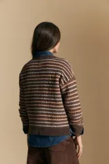 Sweater de punto con diseño de rayas horizontales en tonos tierra, con textura acanalada y cuello redondo. Presenta un corte relajado y mangas largas.