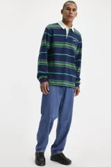 Jean de corte holgado y pierna recta, con diseño de cinco bolsillos y cierre de bragueta. Presenta un lavado azul clásico y un ajuste que se sitúa debajo de la cintura.