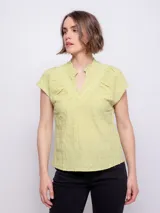 Top de manga corta color verde claro, con cuello mao, abertura en V y tablas en la parte superior.
